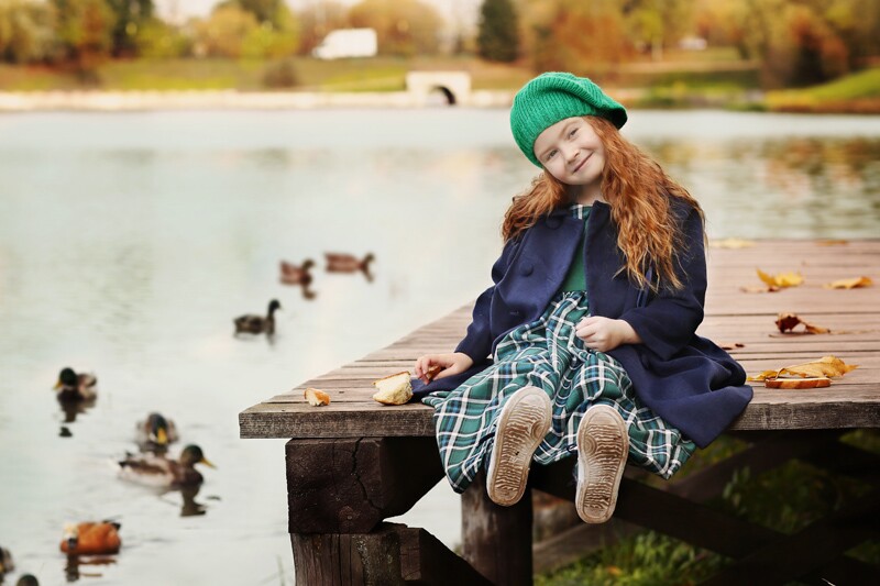 a little irish girl sits on a bridge