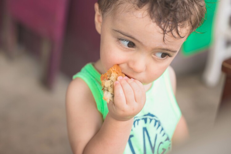 a young puerto rican boy eats food.