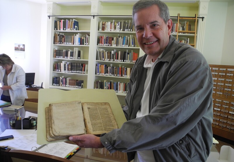 Scott Fisher holding old historical records