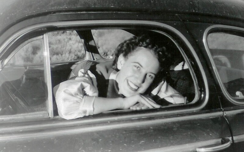 Woman smiling from window of car in 1950