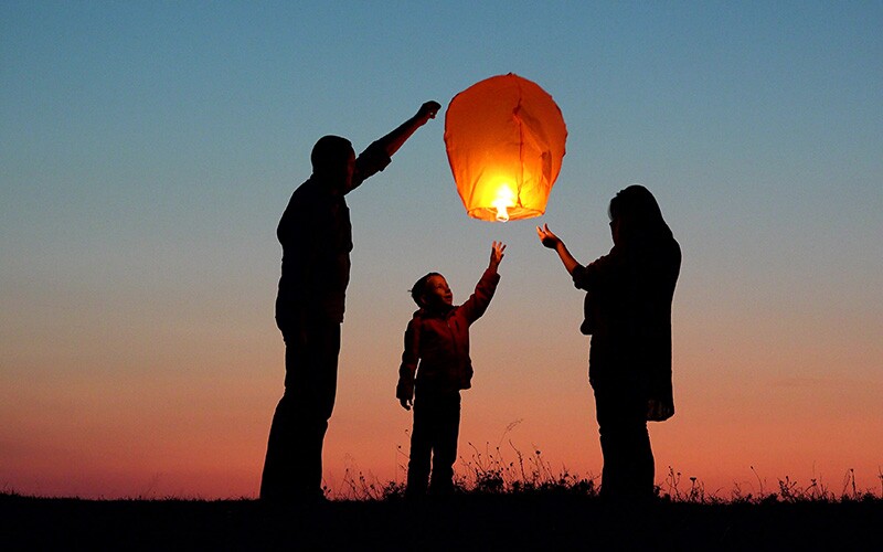 Family lights a lantern in memory of a loved one.