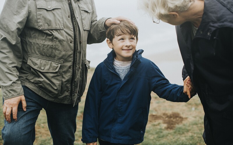 little boy from wales holding grandparents' hands
