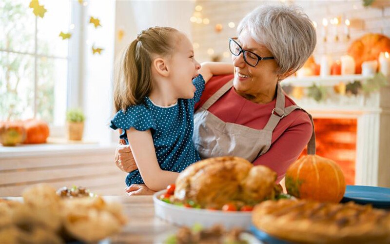 Grandmother and granddaughter enjoy thanksgiving activities.