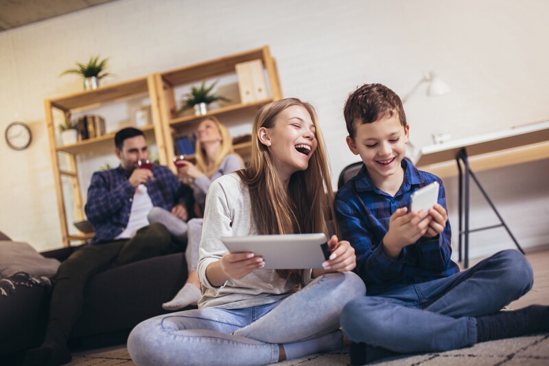 generation z teenage girl and young boy play on phone and ipad