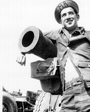 One of the battalion members next to a tank.