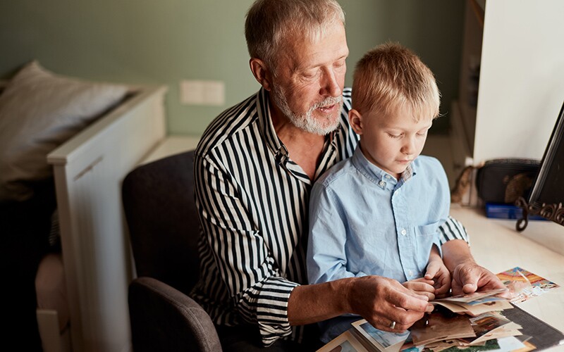 Grandfather and son looking at photos, memories of a loved one.