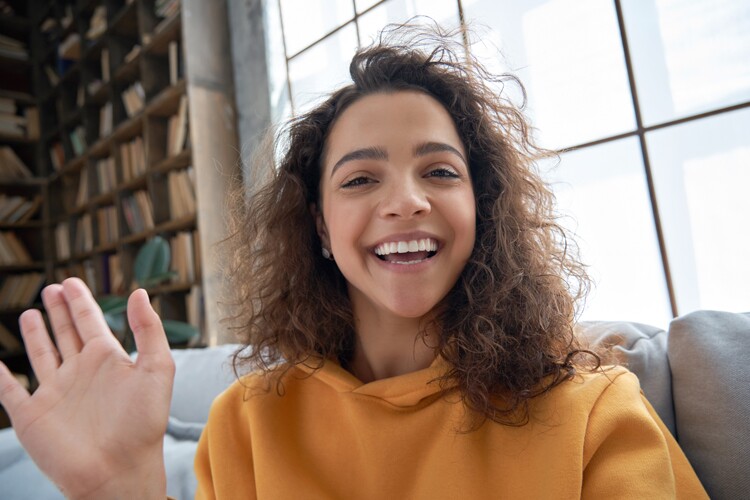 A woman waving to the camera