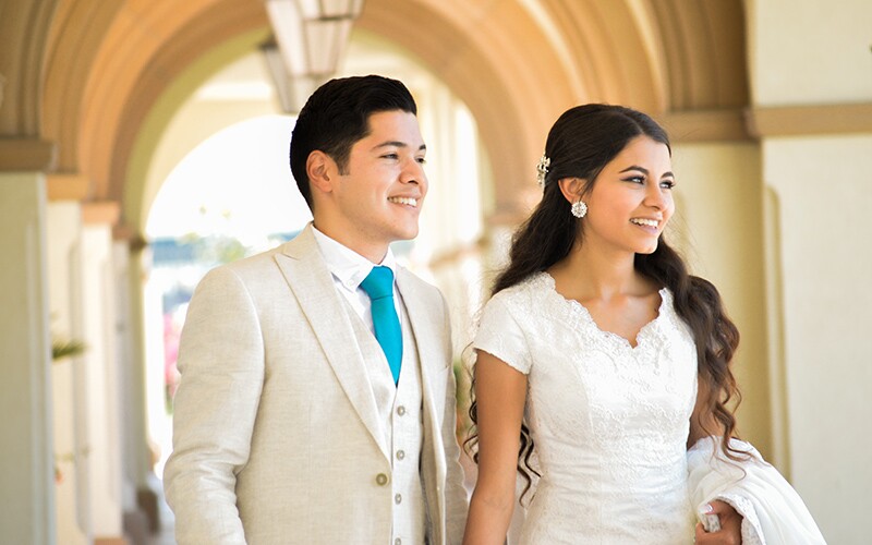 A bride and groom smile off-camera.