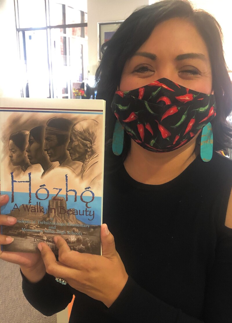 Misty Hozho holding up a copy of Hózhó, A Walk in Beauty.