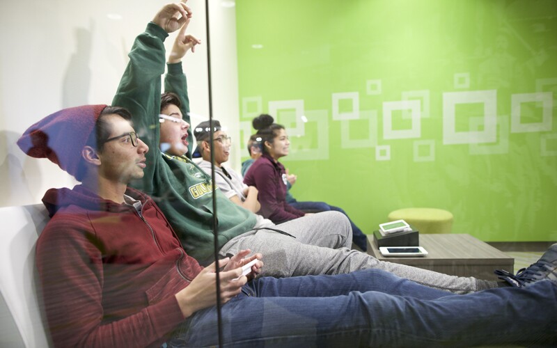 A group of teenagers at the discovery center looking excited while sitting on a couch.