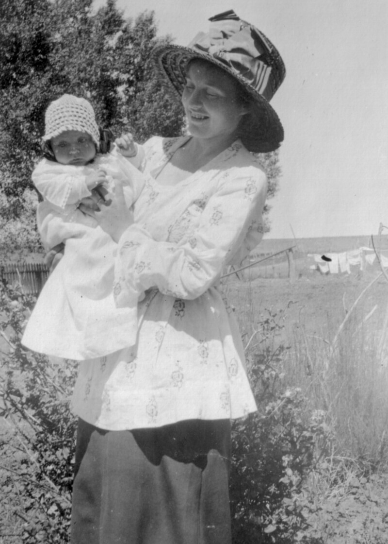 Woman holds baby outside
