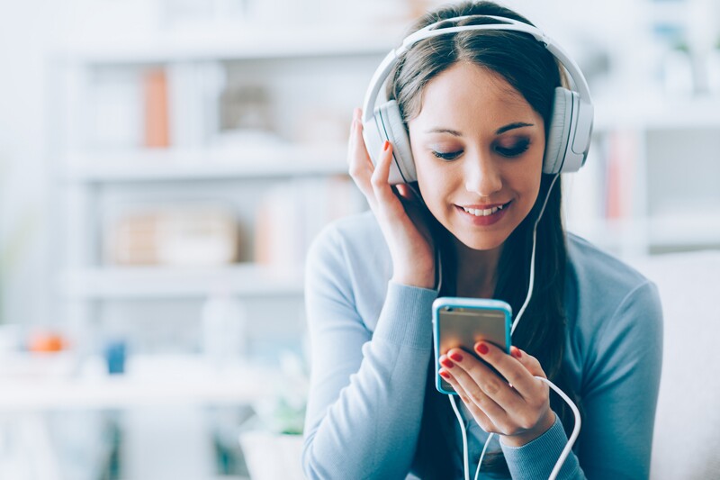 girl listening to musical time capsule, wearing headphones