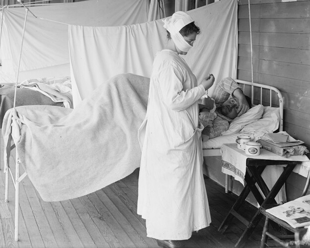 A woman tends to an ill man during the 1918 pandemic. 