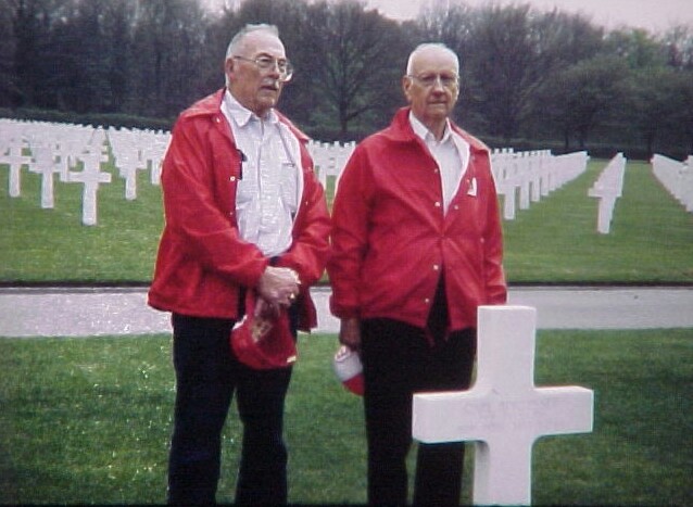 Two men of the 951st battalion at a grave for one of their battalion members.