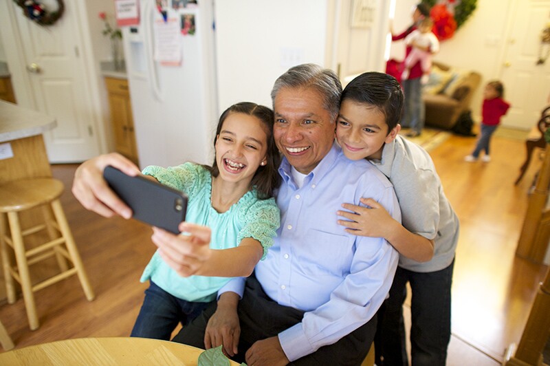 a grandfather takes a photo with his grandchildren.