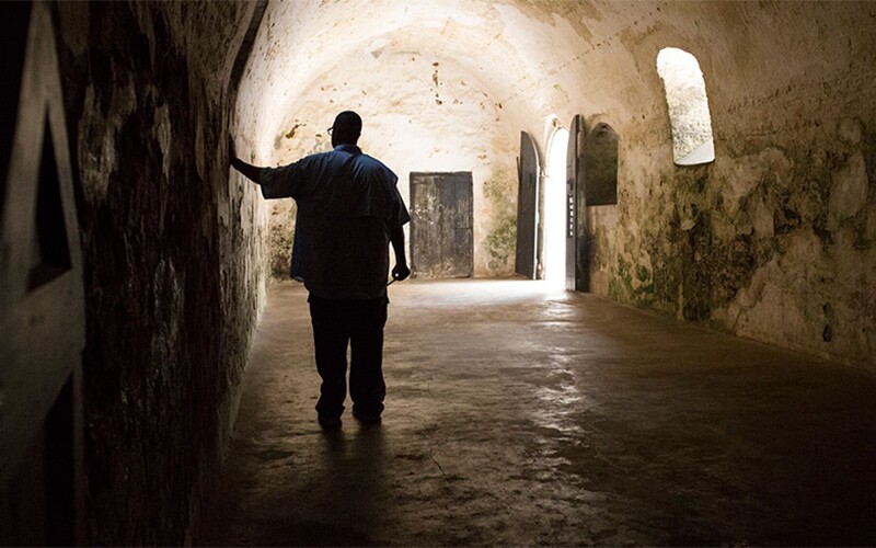 Thom Reed touches the wall of a slave holding cell in Ghana.