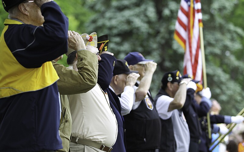 U.S. veterans in a line saluting.