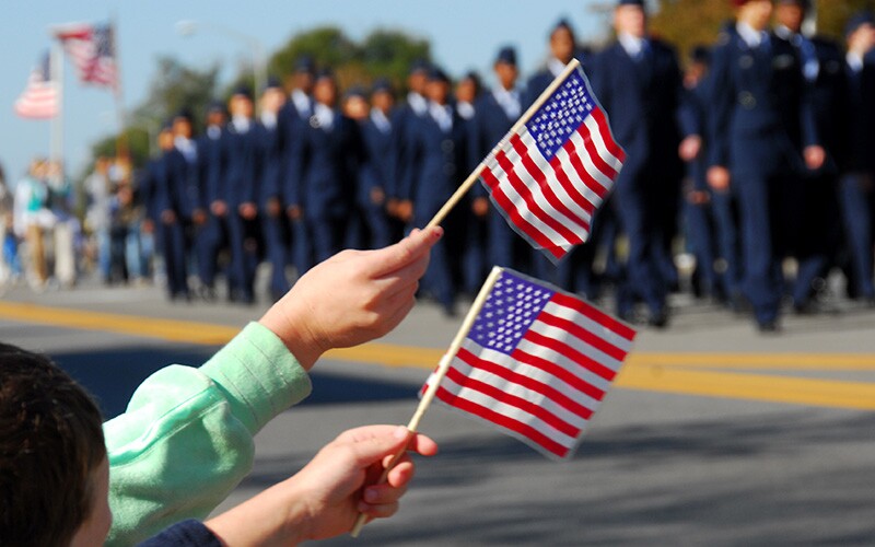 Waving American flags at a Veterans Day parade.