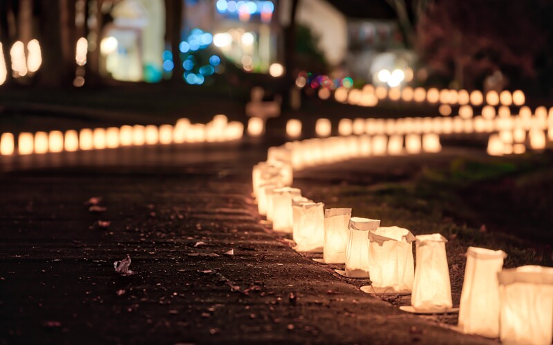 paper lanters light a sidewalk as a house is decorated for the holidays.