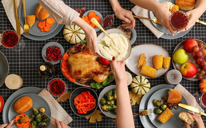 Passing potatoes at thanksgiving dinner table.