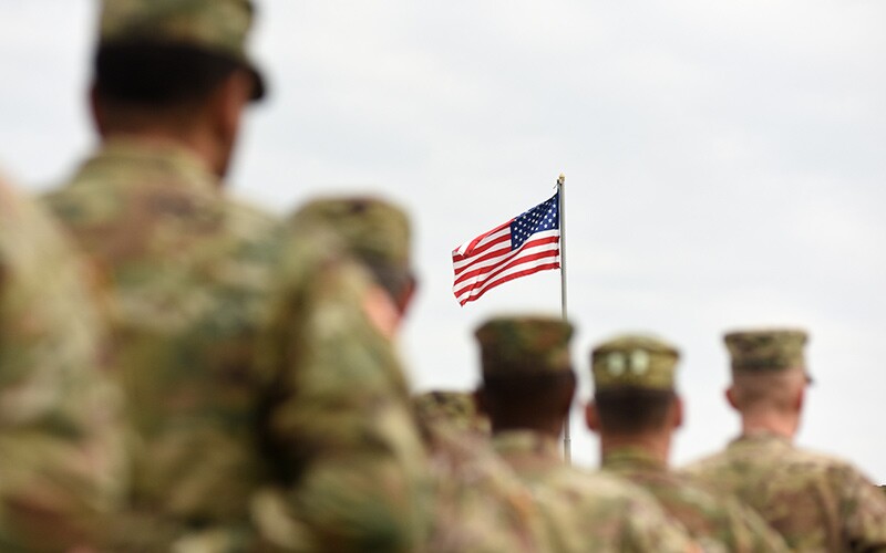 U.S. soldiers march towards the American flag on Veteran's Day.