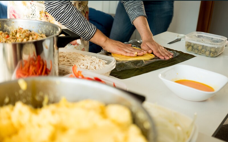 a woman makes hallacas.