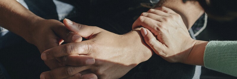 someone comforting another person, putting their hand on the other person's arm