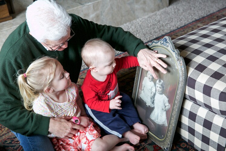 A grandfather shows images to his grandkids.