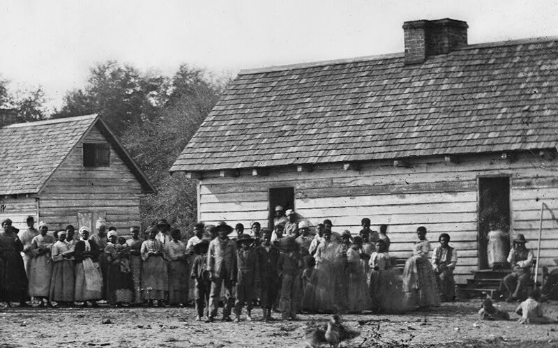 enslaved persons in front of their homes.
