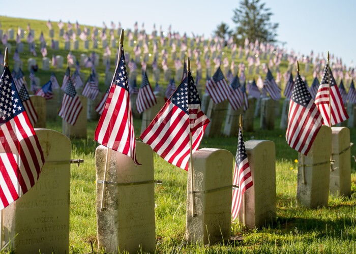 military gravestones with flags.