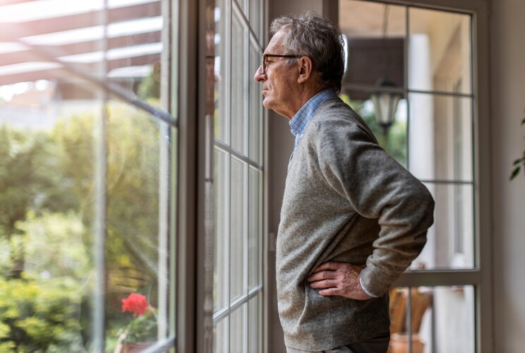 older man looking out window