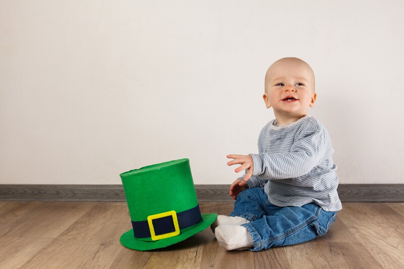 A little boy next to an irish top hat. this boy could have an irish name.