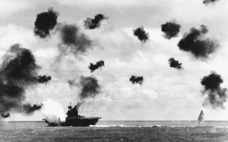 Warship on water with smoke in sky