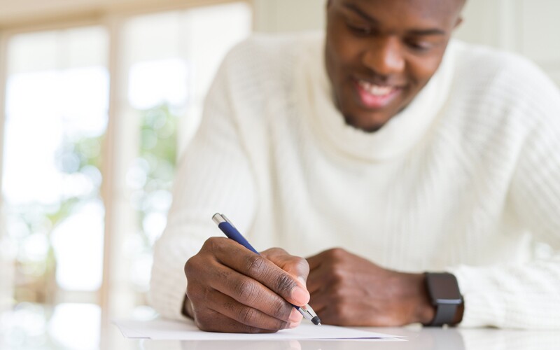 a black man celebrates black history month writes his personal history in a journal